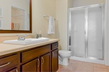 A bathroom with a toilet, sink, and shower.