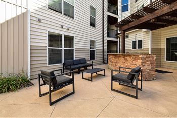 A patio with two black chairs and a table.