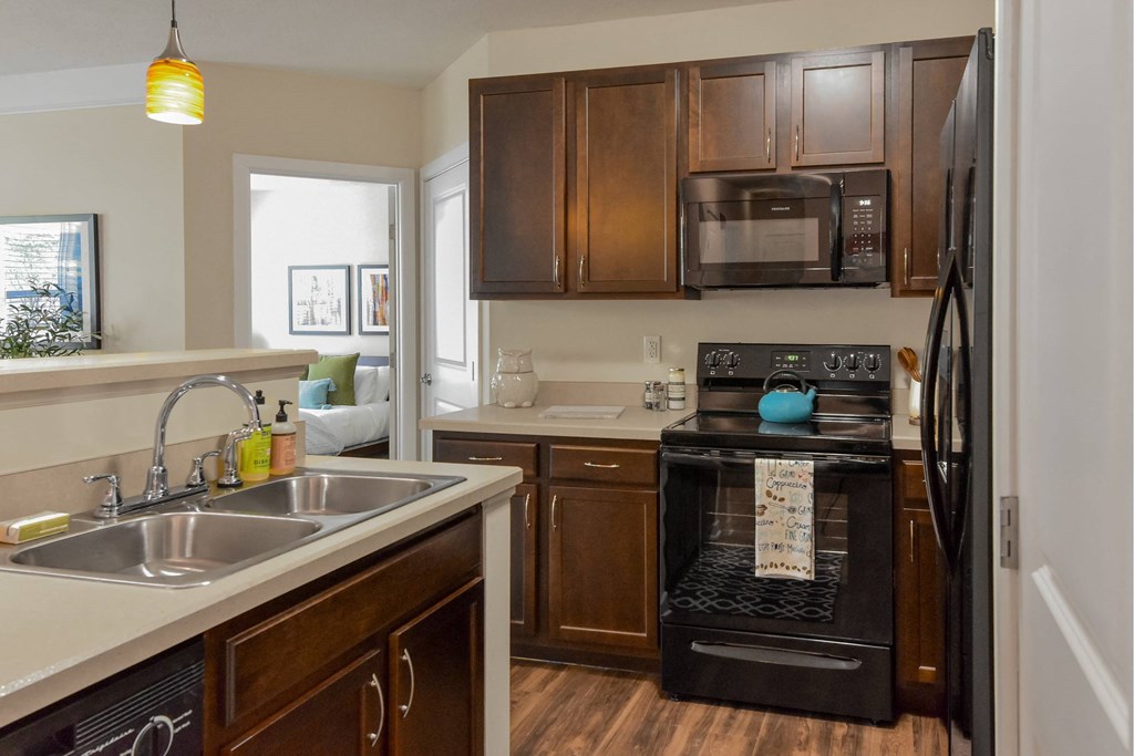 A kitchen with brown cabinets and a black oven.