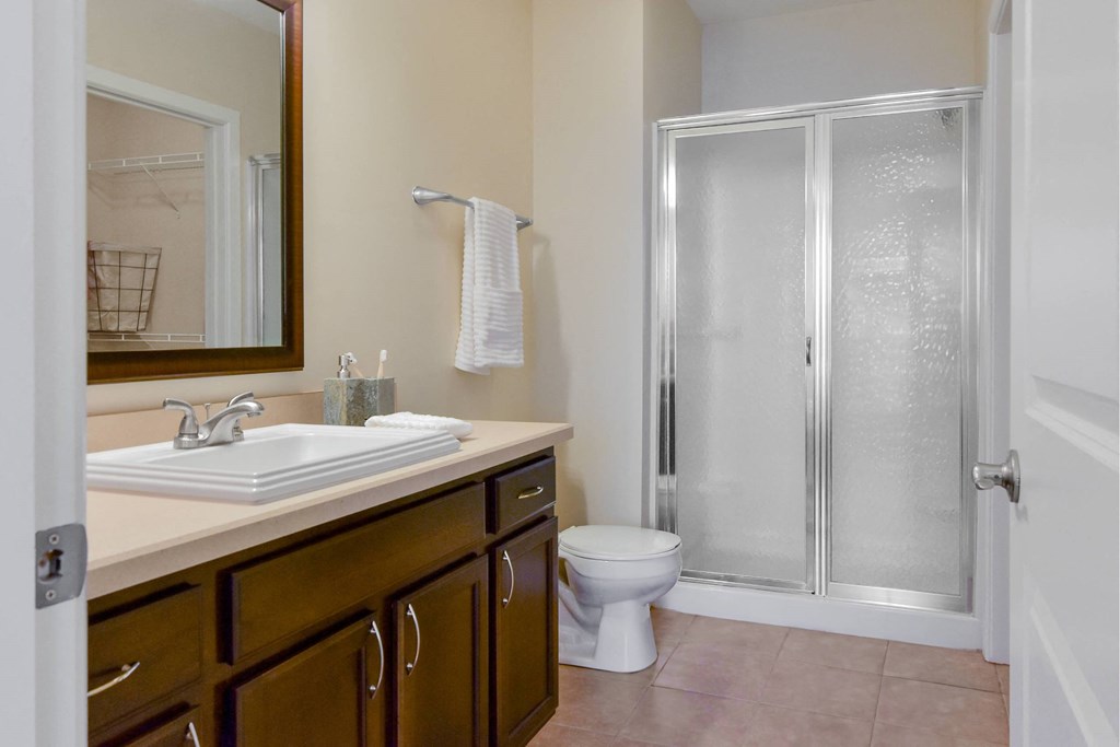 A bathroom with a toilet, sink, and shower.