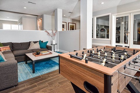 A foosball table sits in the middle of a living room.