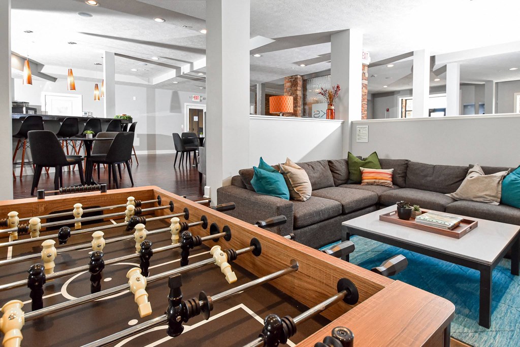 A foosball table is in the middle of a living room.