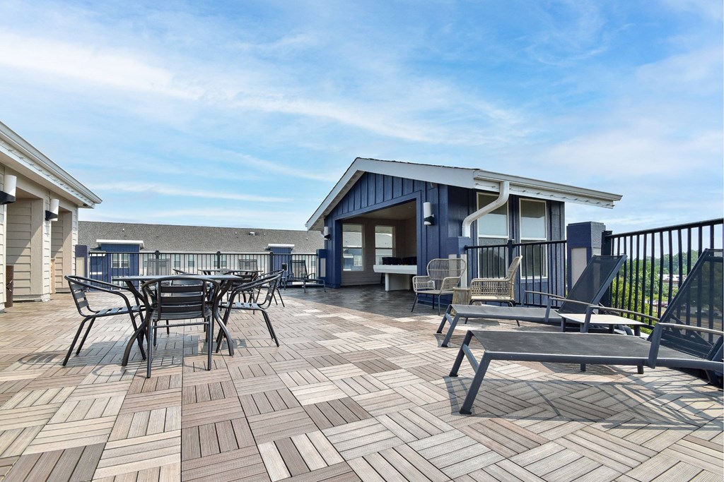 A patio with a table and chairs is surrounded by a black fence.