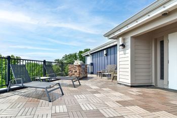 A patio with a table and chairs is surrounded by a black railing.
