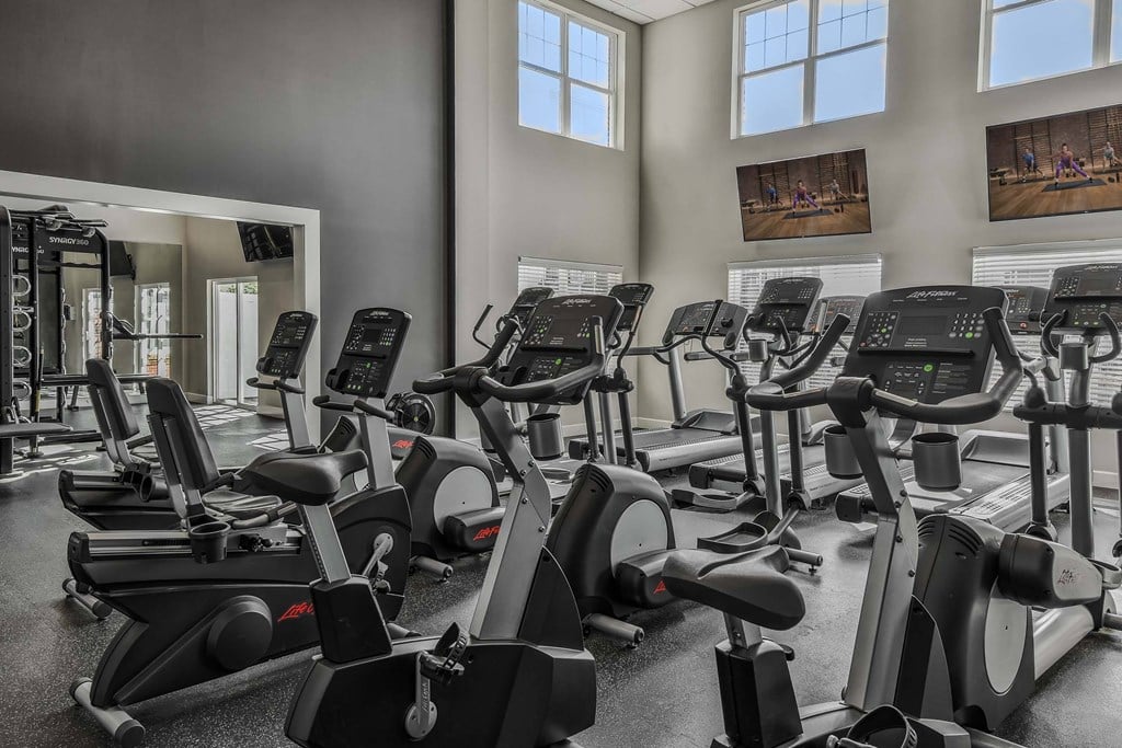 A gym with a row of stationary bikes.