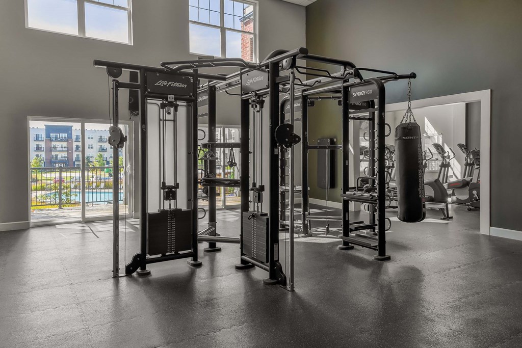 A gym with a punching bag and weightlifting equipment.