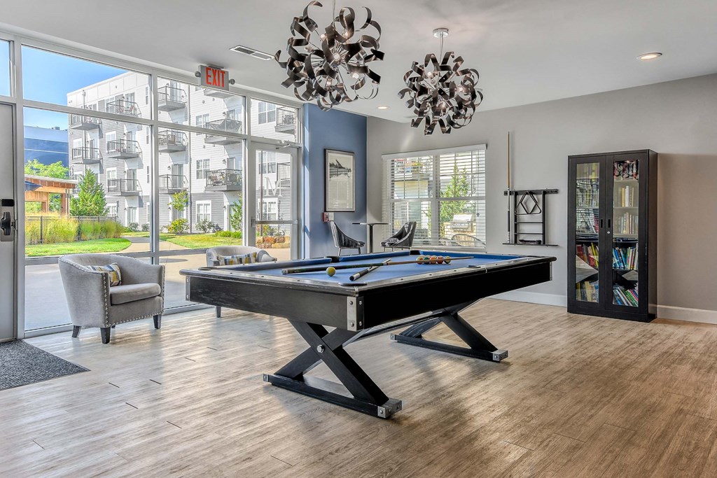 A pool table in a room with a view of the outside.