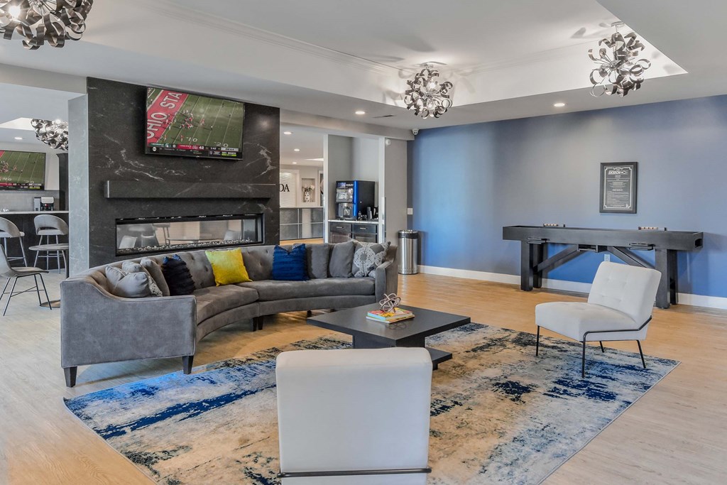 A modern living room with a grey sofa and a television mounted above the fireplace.