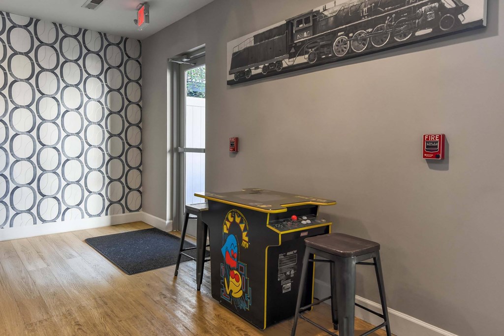 A room with a patterned wallpaper and a train picture on the wall.