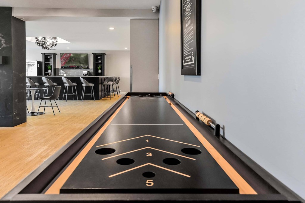 A shiny black air hockey table with the numbers 1, 3, and 5 marked on it.