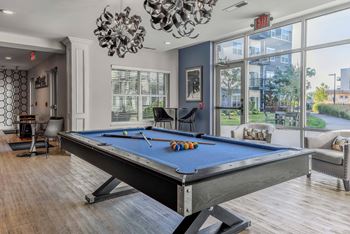 A pool table in a room with a view of the outside.