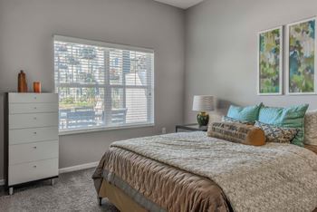 A bedroom with a large bed and a dresser.