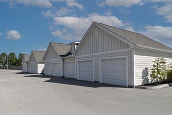 A row of white garages with a clear blue sky above.