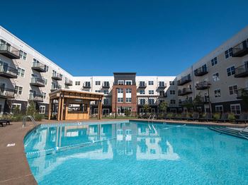 A swimming pool in front of apartment buildings.