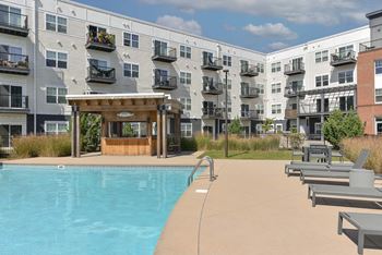 A pool area in front of apartment buildings.