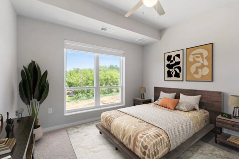 A bedroom with a large bed and a view of the outdoors through a large window.