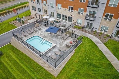 A swimming pool surrounded by a fence in a grassy area.
