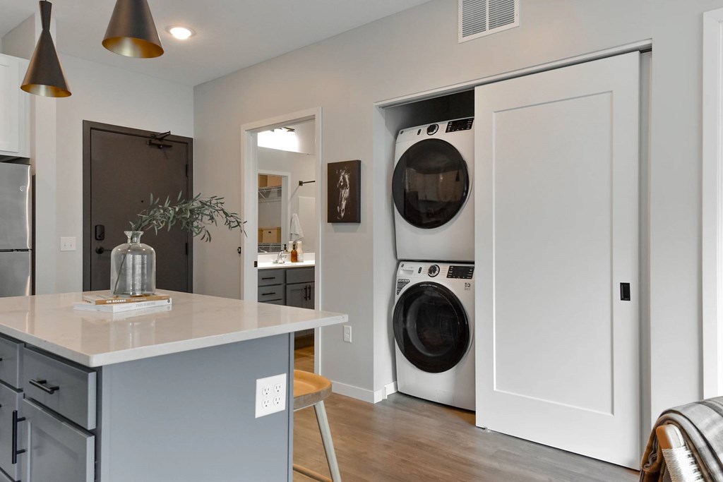 A modern kitchen with a washing machine built into the wall.
