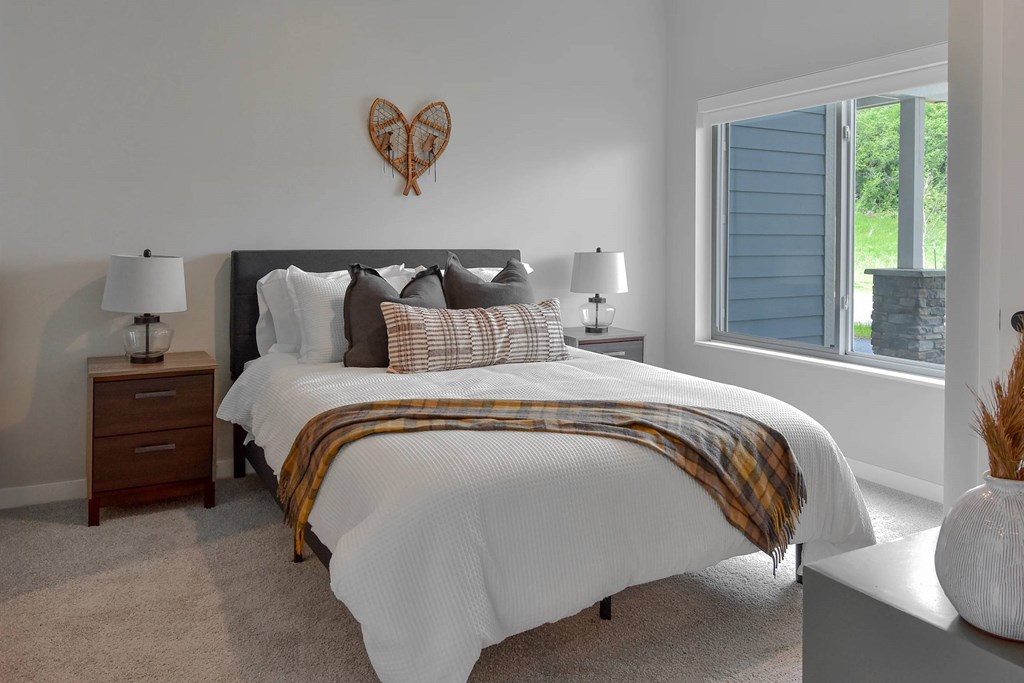 A bedroom with a large bed and a heart-shaped decoration on the wall.