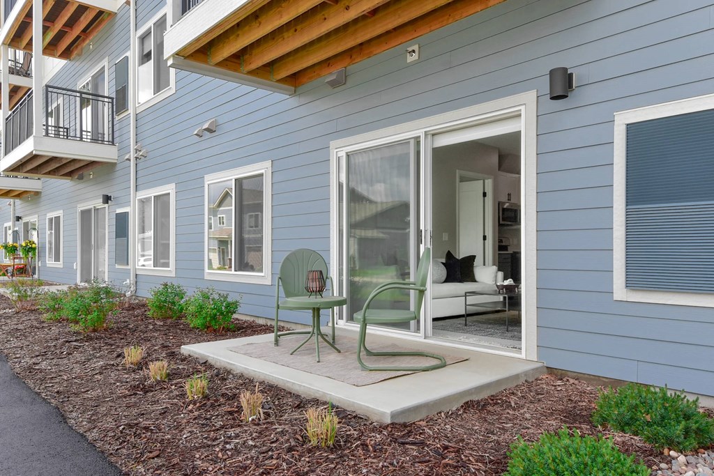 A blue house with a green chair on the patio.
