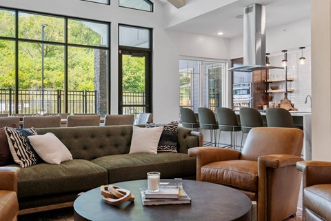 A living room with a green couch and brown leather chairs.