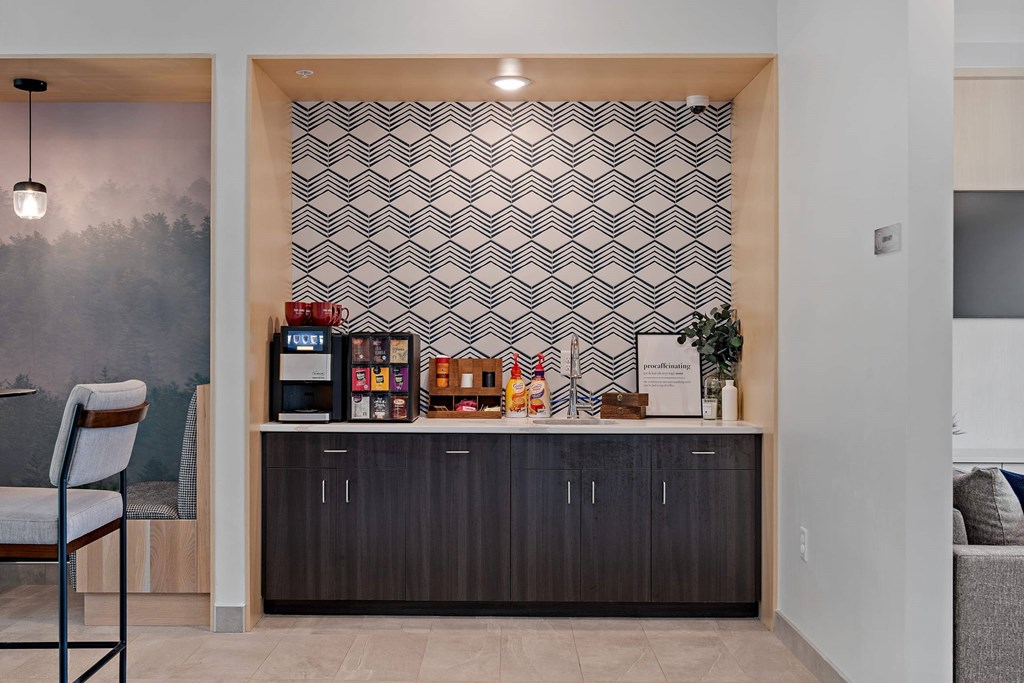 A modern kitchen with a wooden chair and a patterned wallpaper.