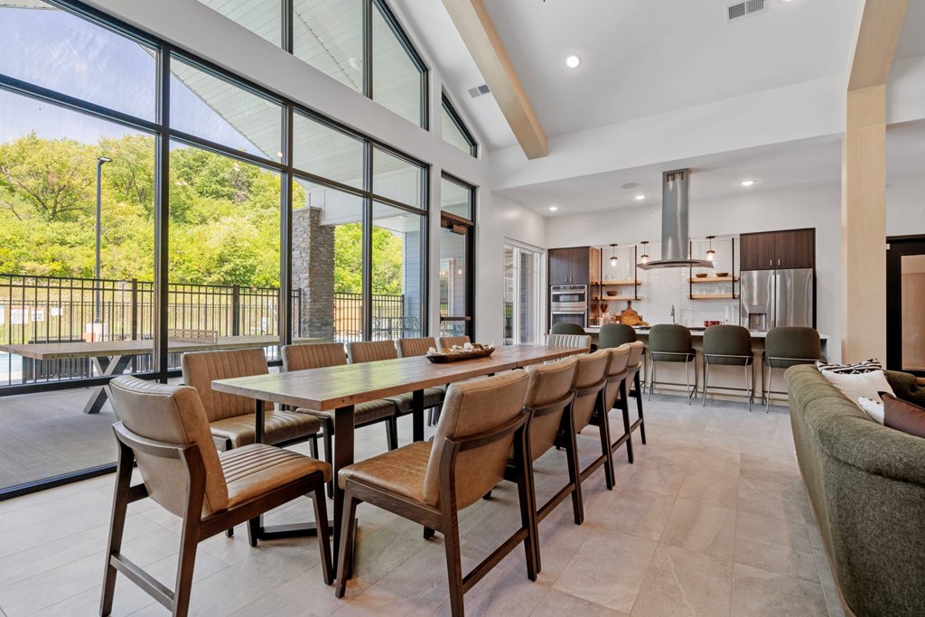 A modern dining room with a long table and chairs.