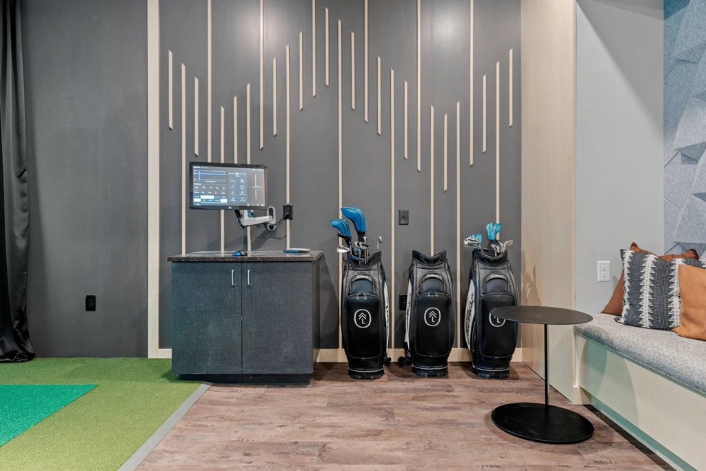 A room with a wall of vents and a row of vacuum cleaners.