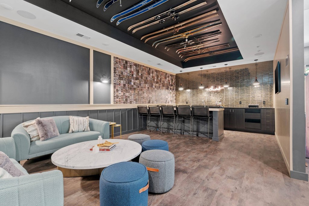 A modern living room with a large couch, a coffee table, and a bar area.