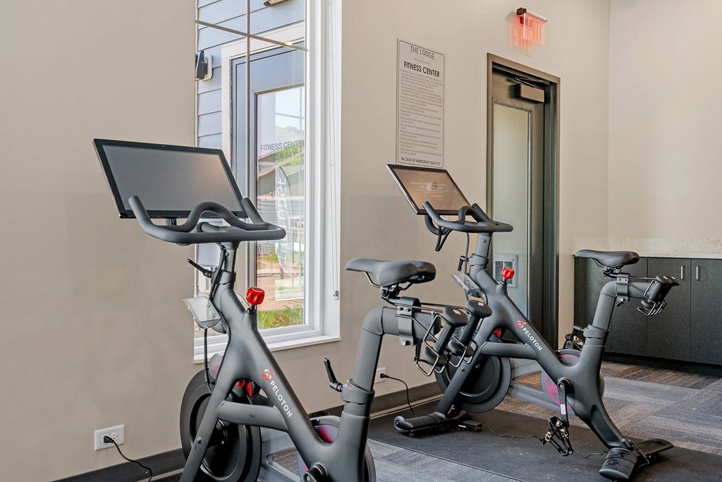Two stationary bikes are in a room with a sign that says "Exercise Center".