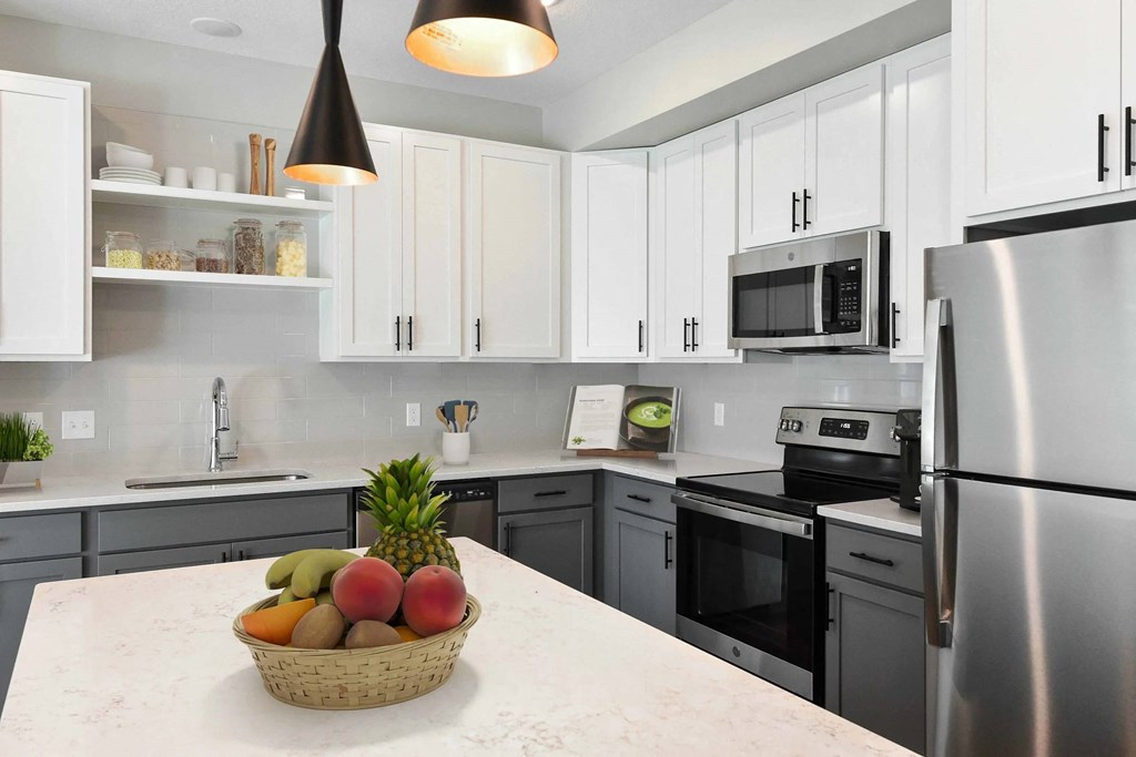 A kitchen with a bowl of fruit on the counter.