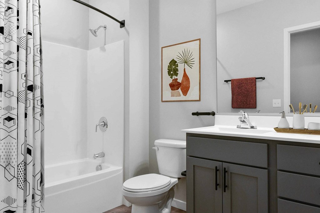 A bathroom with a toilet, sink, and shower.