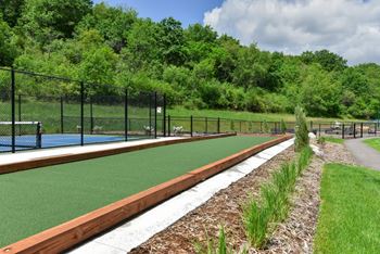 A tennis court surrounded by a fence and trees.