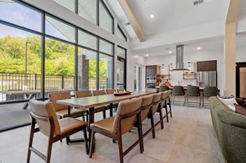 A modern dining room with a long table and chairs.