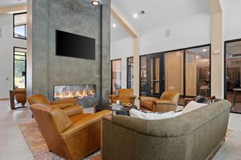 A modern living room with a fireplace and a flat screen TV mounted on the wall.