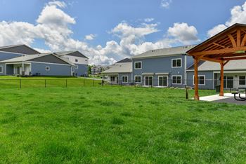 A row of houses with a green lawn in front.