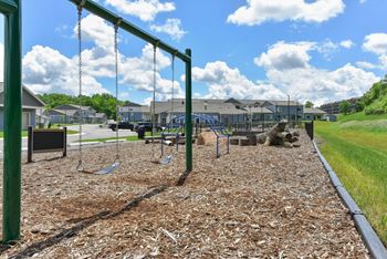 A playground with a swing set and a slide.