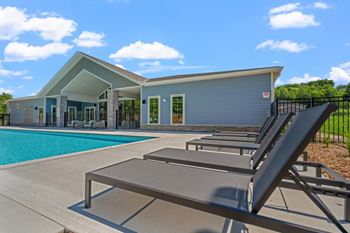 A poolside lounge area with sunbeds and a building in the background.