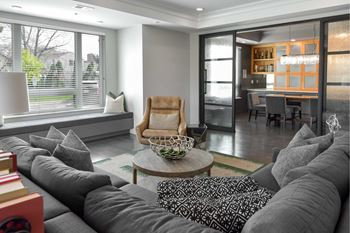 A living room with a grey couch and a wooden chair.