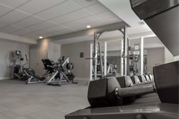A black dumbbell is on a bench in a gym.