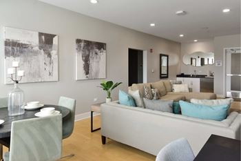 A modern living room with a black dining table and a grey sofa.