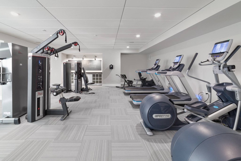 A gym with treadmills, elliptical machines, and other exercise equipment.