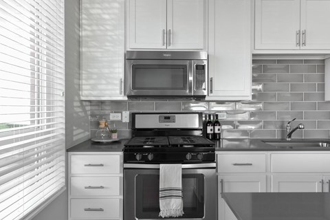 A modern kitchen with white cabinets and a black and white color scheme.