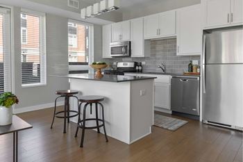 A kitchen with white cabinets and a wooden floor.