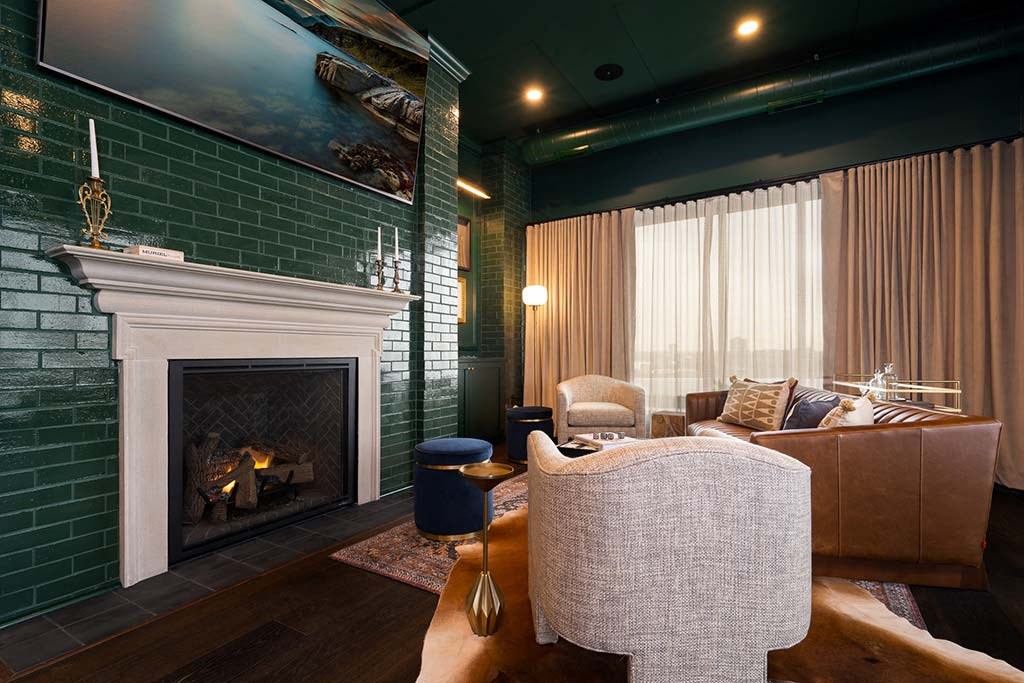 A living room with a fireplace and a painting above it.