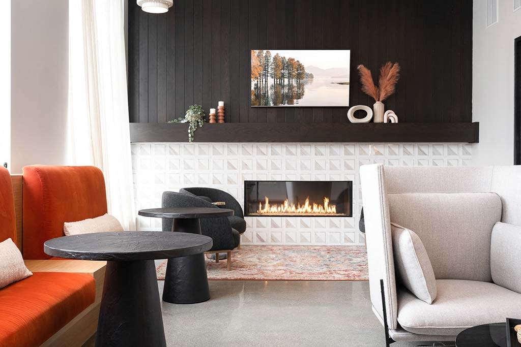 A modern living room with a fireplace and a painting on the wall.