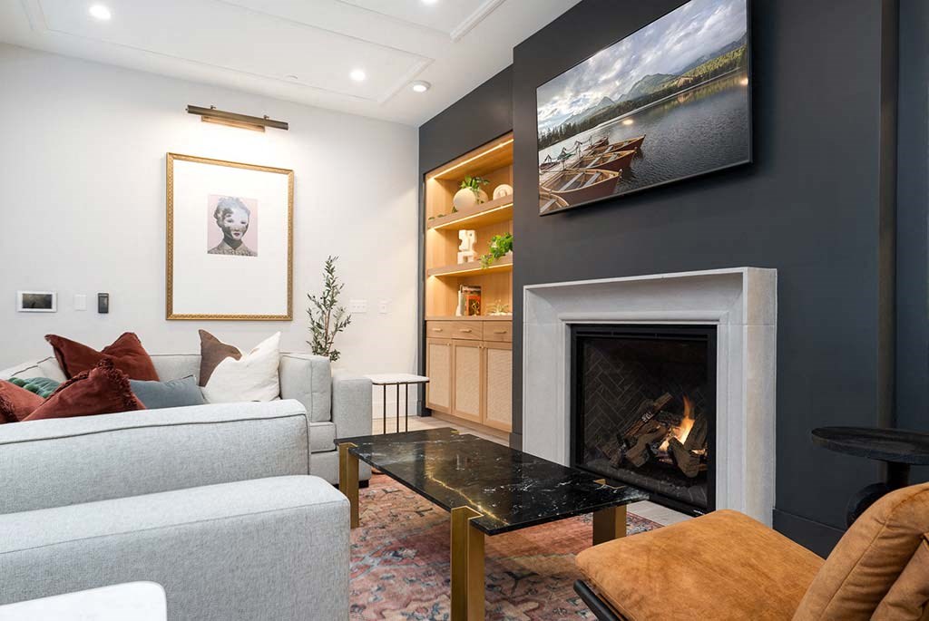 A living room with a grey couch, a black coffee table, and a fireplace.