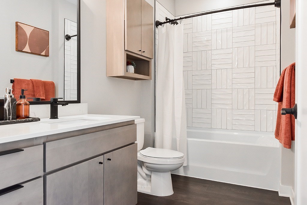 A white toilet sits in a bathroom next to a shower.