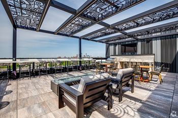 A rooftop patio with a table and chairs.