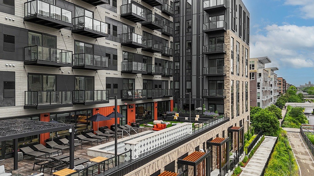 A modern apartment complex with balconies and a pool.